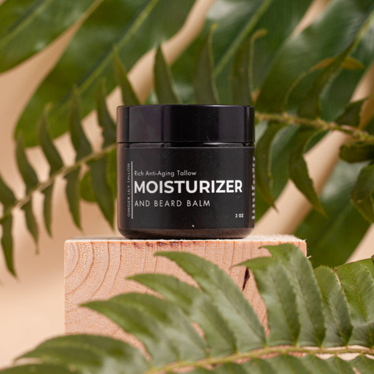 Black jar of moisturizer with leaves in the background
