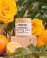 Organic beef tallow whipped tallow balm jar with yellow roses and oranges on a wooden block