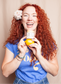 Owner of Ginger Lily Tallow holding a bottle of beef tallow against a beige background